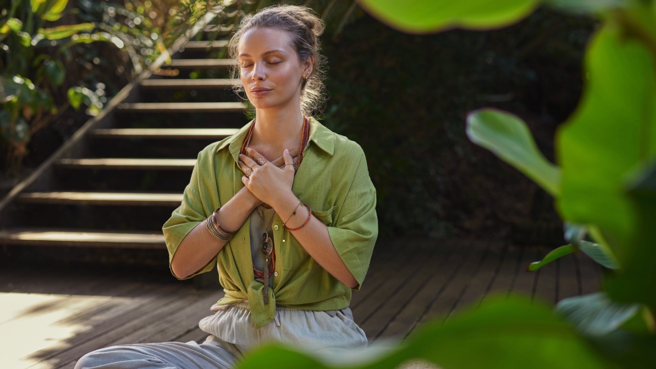 A person meditating with hands over the heart